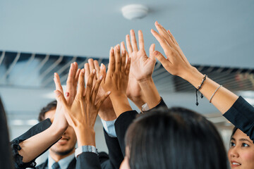 Many happy business people raise hands together with joy and success. Company employee celebrate...