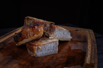 Roasted pork entrecote cut into pieces on a wooden cutting board. Grilled pork entrecote. Pork steak.