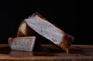 Roasted pork entrecote cut into pieces on a wooden cutting board. Grilled pork entrecote. Pork steak.