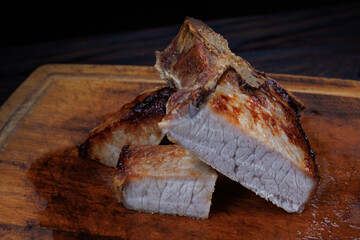 Roasted pork entrecote cut into pieces on a wooden cutting board. Grilled pork entrecote. Pork steak.