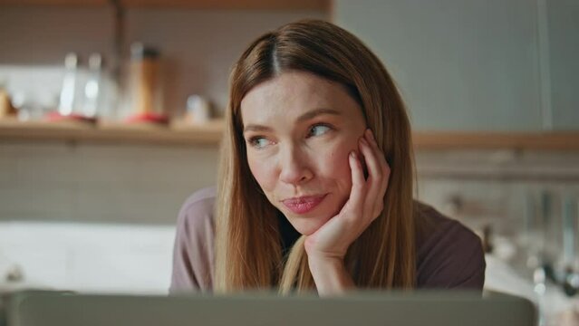 Cheerful lady video chatting looking laptop web camera in home kitchen close up.