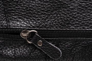 Black leather bag with metal zipper close up. Background and texture.