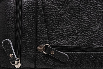 Black leather bag with zipper close-up. Fashionable background.