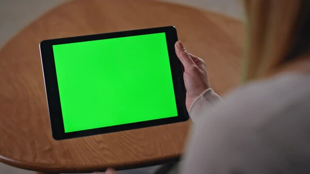 Online customer zooming chroma key tablet shopping remotely at home close up.