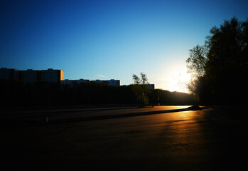 Sunset on empty car parking place cityscape backdrop