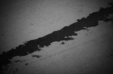 Diagonal water splash trace on grey asphalt texture backdrop