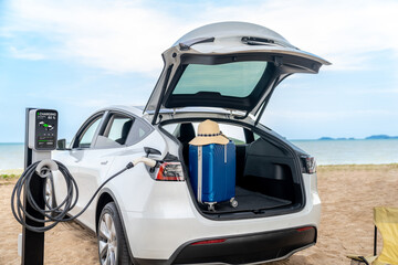 Road trip vacation traveling to the beach with electric car recharging battery with alternative...