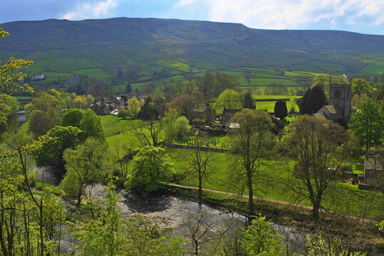 Burnsall in Wharfedale with the anchient arched bridge over the river Wharfe, a village green and St Wilfrid's Church, North Yorshire, England, UK