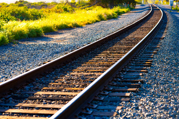 Curved single-track railroad along the Pacific Coast in Carpinteria, California on a sunny day. The...