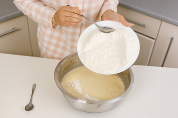Young girl is cooking breakfast in the kitchen