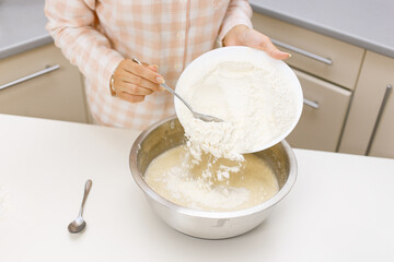 Young girl is cooking breakfast in the kitchen