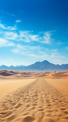 A vast expanse of sand dunes in the middle of a desert with mountains in the distance