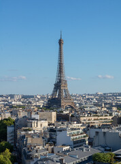 Naklejka premium Panoramic view of the Eiffel tower, on the Parisian buildings in the center, Arc de Triomphe de l'Étoile, located on the Charles de Gaulle square, and at the western end of the Champs Elysées avenue 