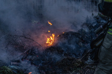 The Workers Extinguish Fire with Water from The Garbage Pile