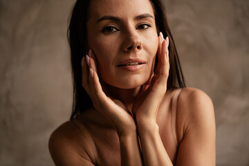 Portrait stunning flawless caucasian woman touching cheeks with wrinkles on face applying trendy...