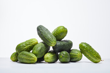 Heap of ripe cucumbers on a white background