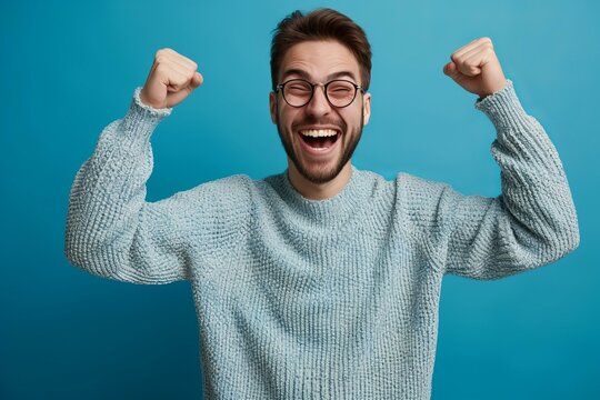 Bearded man in glasses celebrating with raised fists