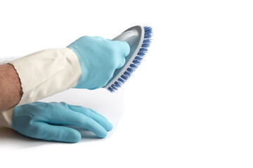 hands in blue rubber gloves holding a bristle brush ready for cleaning isolated on white - obrazy, fototapety, plakaty