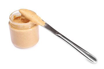 Tasty nut paste in jar and knife isolated on white