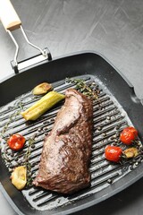Delicious grilled beef meat and vegetables in pan on grey table, closeup