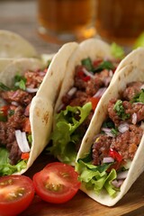 Delicious tacos with meat and vegetables on table, closeup