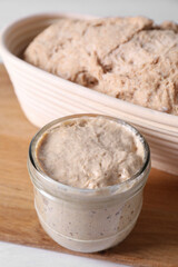 Fresh sourdough starter and dough on table, closeup