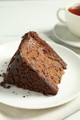 Piece of delicious chocolate truffle cake on table, closeup