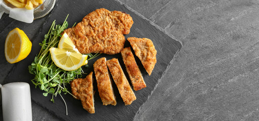 Tasty schnitzels served on grey table, top view. Banner design