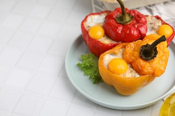Delicious stuffed bell peppers with fried eggs on white tiled table, space for text