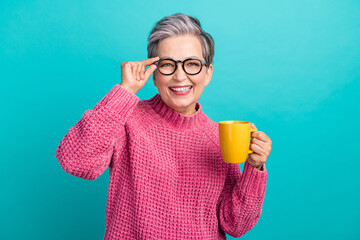 Portrait of intelligent cheerful woman wear pink pullover touching glasses holding cup of cacao isolated on turquoise color background