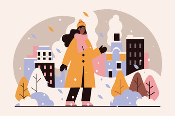 Naklejka premium A woman strolls amidst snow-covered trees and buildings