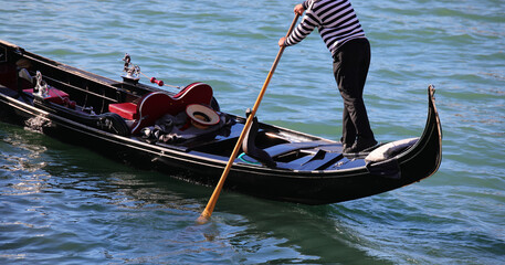 Gondolier with oar on the Gondola Boat while rowind in the Grand Canal in Venice