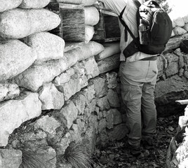 soldier with backpack inside the trench dug in the ground with black and white effect