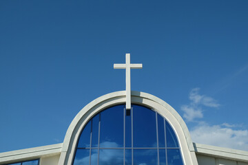 There is a cross on the dome of the church. Against the background of the blue sky.