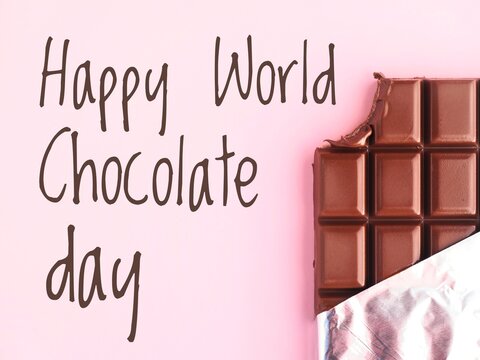 Happy World Chocolate day celebration poster with text and a partially unwrapped chocolate bar with a missing bite on a pink background