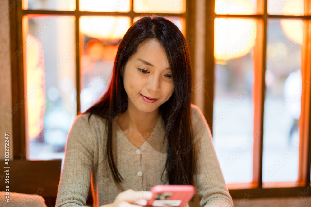 Wall mural Woman use smart phone to order food at restaurant