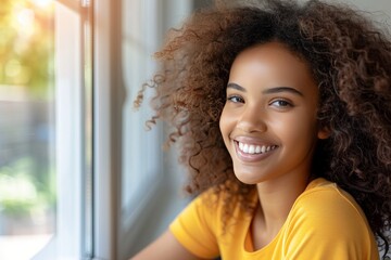 Obraz premium Radiant woman with curly hair smiling gleefully and joyfully gazing through a window