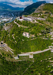 Aerial view of Grenoble's Bastille fort, city skyline crossed by the river and surrounded by mountains. France