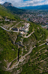 Aerial view of Grenoble's Bastille fort, city skyline crossed by the river and surrounded by...