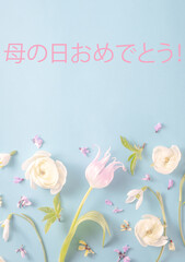 Text Happy mother's day in japanese. floral flat lay from cream ranunculus on a soft blue...