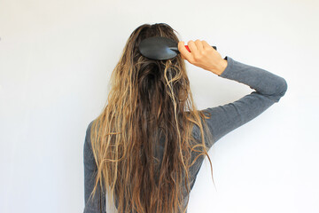 woman combing long tangled hair