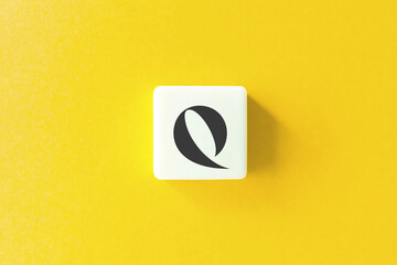 Capital Letter Q. Text on Block Letter Tiles against Yellow Background.
