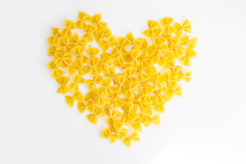 Uncooked "bow-tie pasta" (farfalle). Raw pasta with a bow tie (farfalle) in the shape of a heart.
