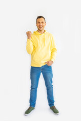 Full body young overjoyed excited happy cool fun man 20s wear casual yellow hoodie he do winner gesture isolated on white background studio portrait. People lifestyle concept. 