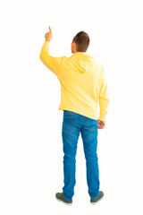 The young man in yellow hoodie turned his back to the camera and pointed at something isolated on a white background.