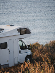 Coach built white motor home parked by the sea