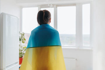 Conceptual Loyalty Woman's Rear View with Ukrainian Flag Indoors