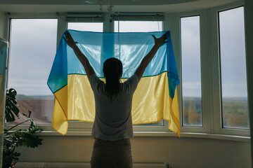 United in Pride Woman's Rear View with Ukrainian Flag by Window