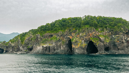 A series of eroded sea caves, including the Kunne-Poru (Black Caves), located on the southern coast of the Iwaobetsu River in Shiretoko Peninsula, Hokkaido of Japan.