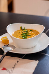 Cream pea soup with parsley and lentil on black rustic background. 